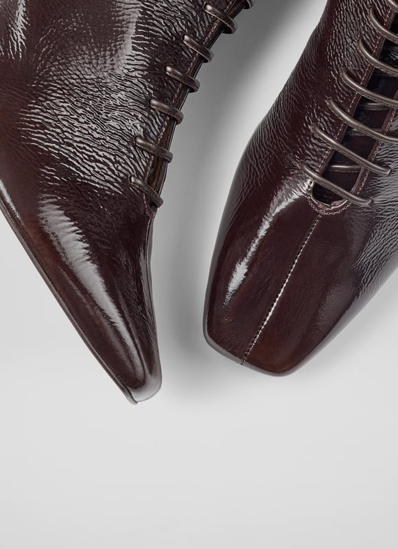 Experience sophistication with every stride. Our Arabella lace-up ankle boots in rich espresso crinkled patent boast a stylish square toe and a sturdy block heel, all exquisitely lined with leather. Perfect for smart-casual ensembles, pair them with tailored trousers or your favourite dress. These lace-up ankle boots are the epitome of style and function. Made in Spain.