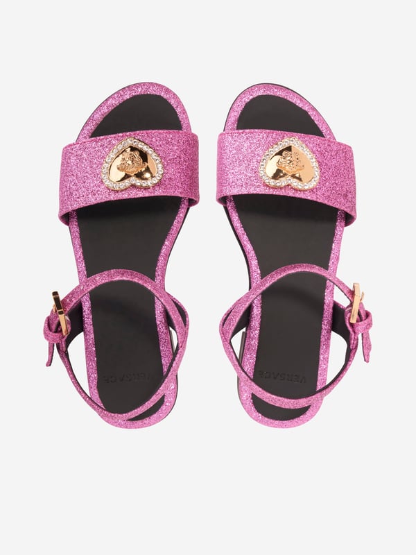 Presenting the luxurious Girls Medusa Heart Sandals in Pink by Versace. A summer essential, these sandals blend sophistication and comfort for your little girl's outings. Major highlights include: Made in Italy: Expertly crafted with the most exquisite detail, we promise durability and long-lasting use that Versace stands for. Medusa Heart Motif: These sandals feature a trendy Medusa heart motif, rendering a playful yet stylish appeal that promises to make your girl stand out. Premium Comfort: Made from top-notch materials ensuring maximum comfort for your little girl feet, allowing her to enjoy her summer adventures. Add a touch of elegance to your girl's wardrobe with Versace's Medusa Heart Sandals in Pink. Shop now, for an infusion of Italian sophistication into her style!