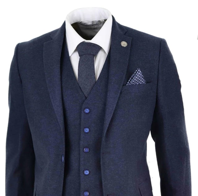 Ein blauer Anzug ist ein Grundbestandteil der Garderobe eines jeden Mannes und dieser hier ist keine Ausnahme von dieser ungeschriebenen Regel. Scharf, elegant und raffiniert – sehen Sie gut aus mit diesem hochwertigen dreiteiligen marineblauen Woll-Tweed-Anzug mit Slim-Fit-Schnitt, engerer Passform an der Brust und schmaler geschnittenen Hosen. Die Zwei-Knopf-Jacke fällt wunderschön und hat eine halbe Canvas-Konstruktion, die sich Ihrer Körperform anpasst, je mehr Sie sie tragen. Mit Taschenpaspeln aus Samt, geknöpften Manschetten und einem einzelnen Rückenschlitz verleihen dem Anzug einen klassischen Hauch von Raffinesse. Eine passende Tweedweste vervollständigt den Dreiteiler im einreihigen Daunenstil mit klassischen maßgeschneiderten Taschen und einem Rückenversteller, um sicherzustellen, dass Sie Ihre ideale Passform kreieren können. Der Anzug ist immergrün und zeitgemäß zugleich und ermöglicht es Ihnen, den ganzen Tag über gut auszusehen. Kombinieren Sie es mit einer passenden Weste, einem weißen Hemd und Schuhen für ein elegantes Finish.