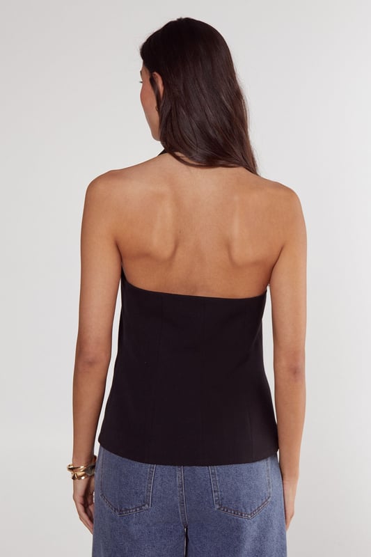 Sleek tailored vest with button front closure
        Plunging V-neckline for a sophisticated look
        Halter-style design with open back
        Single decorative button detail at the waist
        Versatile piece for layering or wearing alone
    
    Elevate your workwear wardrobe with this chic tailored vest from NastyGal's Essentials collection. Perfect for the modern professional, this sleek piece offers a contemporary twist on classic office attire. Style it over a crisp white shirt and pair with tailored trousers for a polished look that commands attention in the boardroom. For a more relaxed yet refined ensemble, layer it over a lightweight turtleneck and team with high-waisted wide-leg trousers. The vest's versatility shines through as day turns to night - simply pair it with sleek cigarette trousers and statement earrings for after-work drinks. With its ability to transition seamlessly from desk to dinner, this tailored vest is a must-have addition to any fashion-forward professional's wardrobe.