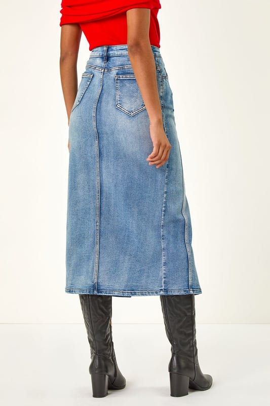 Dusk Panelled Denim Skirt from Roman. Add a touch of retro-inspired style to your Autumn/Winter wardrobe with this chic denim skirt. In a classic denim blue hue, this knee-length skirt features stylish panel detailing for a unique look. The skirt is finished with a secure button fastening for added detail. Pair with cosy knitwear and boots for a timeless and on-trend outfit that's perfect for the cooler seasons!