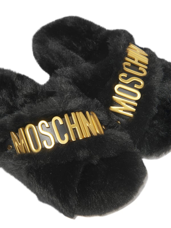 These Moschino Kids Girls Faux Fur Slippers add a touch of luxury to any wardrobe. Crafted from a soft blend of 88% Polyester and 12% Calf Leather, they feature a classic black hue, a furry surface and the iconic logo on the sides. Perfect for casual and formal occasions.·  Moschino Kids·  Made in Italy·  Occasion: Casual·  Print