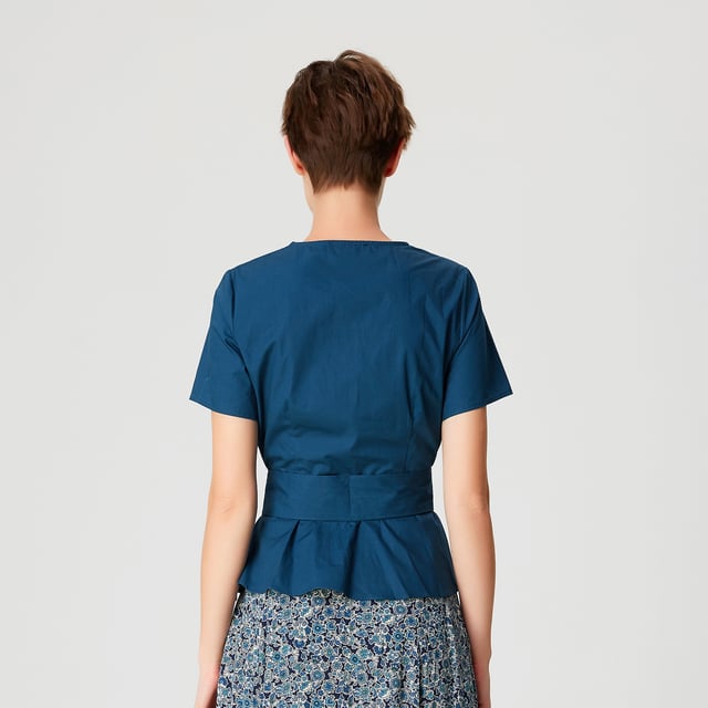 Dieses feminin und raffiniert geschnittene Oberteil ist mit einem breiten Gürtel verziert, den man entweder vorne oder hinten binden kann. Die Brust wird durch einen V-Ausschnitt, der durch einen Kreuzausschnitt entsteht, elegant betont und mit Brustabnähern unterstrichen. Zu kombinieren mit einem geraden Rock oder einer Zigarettenhose.
 Einzelheiten zum Produkt
- Form: tailliert und ausgestellt
- Kurze Ärmel
- V-Ausschnitt
- Unsichtbarer Reißverschluss an der Seite und Druckknopf am Dekolleté
- Länge: 57 cm