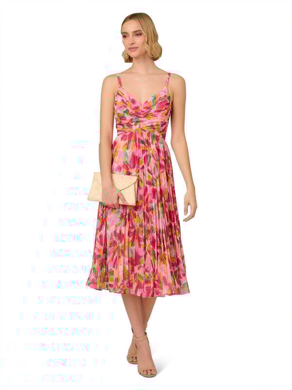Romantic design details flourish throughout this midi dress. This dress features a shirred bodice with tank straps, v-neckline, and pleated soft skirt. Crafted from lightweight chiffon that is covered in a bright, abstract floral print, this dress has limited stretch and a waist seam. A scoop back and hidden zipper closure completes this midi dress. Pair this dress for day with a simple sandal or dress it up for a cocktail attire event with metallic heels and sparkling accessories.