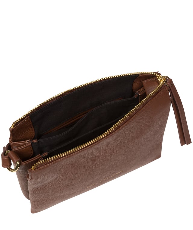 The 'Niki' cross body bag from the Pure Luxuries Marylebone collection is handcrafted from high-quality, genuine Nappa leather with a natural super-soft touch. The zip-over top opens to reveal a 100% cotton-lined interior. The spacious interor features three divided sections, a slip pocket and three card slots. The slip pocket on the rear of the bag provides on-the-go storage and comes with a matching and adjustable slim leather strap with a maximum drop length of 65cm. The Pure Luxuries logo is embossed in gold foil for a beautifully simple finishing touch.