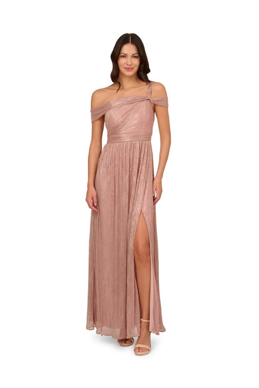 Take the spotlight in this dreamy metallic gown. This formal dress features a shirred bodice with an asymmetrical neckline, draped shoulder sleeves and a single strap at one side, and a side slit cut out of the soft skirt. Crafted from crinkle metallic fabric, this evening gown is fully lined. A zipper closure at the centre back completes the design. Nude heels and a beaded clutch are the perfect accessories to complete this dress for formal and black-tie events.