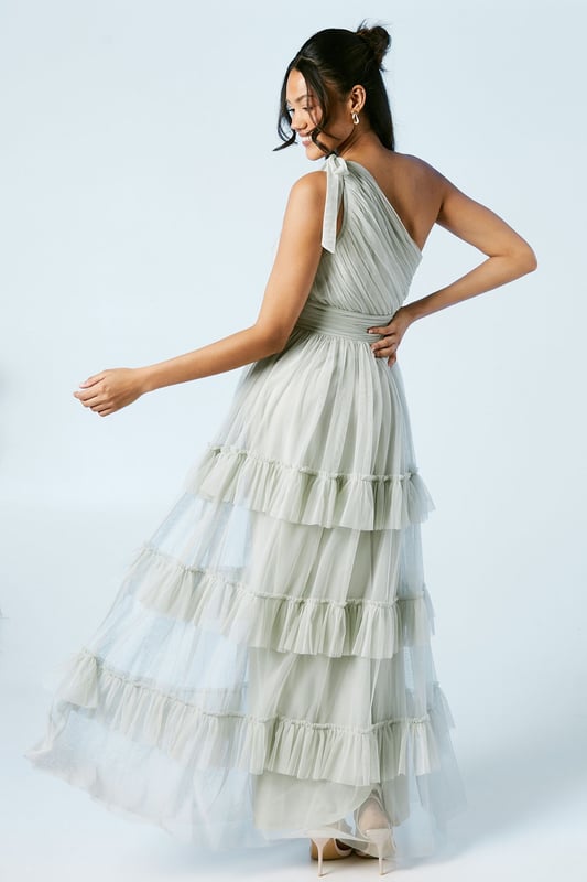 Elegant one-shoulder neckline with pleated detail
        Tiered mesh skirt for a romantic, flowing silhouette
        Floor-length design perfect for formal occasions
        Fitted waistline to accentuate your figure
        Delicate mesh fabric for a light and airy feel
    
    This stunning bridesmaids dress from Oasis is the epitome of grace and sophistication. The one-shoulder neckline adds a touch of modern elegance, while the pleated bodice creates a flattering silhouette. The tiered mesh skirt cascades beautifully to the floor, creating movement and drama with every step. Perfect for your role in the bridal party, this dress will ensure you look and feel fabulous throughout the wedding celebrations. Style with delicate drop earrings and a simple bracelet to complement the dress's intricate design. For a cohesive bridal party look, coordinate with your fellow bridesmaids by choosing matching or complementary accessories. Complete the ensemble with strappy heels and a small clutch bag to hold your essentials. This versatile dress will make you feel confident and radiant as you support the bride on her special day.