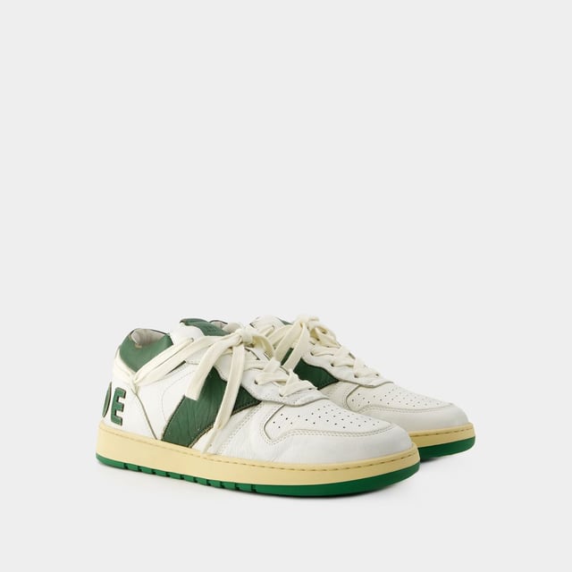 Presentamos las zapatillas Rhecess de Rhude, donde la frescura urbana se une a la comodidad contemporánea. Estas zapatillas fusionan a la perfección un diseño moderno con un guiño al estilo streetwear, mostrando una silueta única perfecta para ir a la moda statement. Para elevar tu look con estas zapatillas statement, considéralas la base de un conjunto moderno de inspiración callejera. Combínalas con unos vaqueros desgastados, una sudadera con capucha de estampado gráfico y unas gafas de sol atrevidas para conseguir un look vanguardista sin esfuerzo, perfecto para un día con amigos o una noche informal en la ciudad. Rhude Las zapatillas Rhecess de brand ejemplifican el compromiso de la marca con la calidad y la moda, ofreciéndote una opción de calzado distintiva y versátil que combina sin esfuerzo el encanto moderno con el estilo urbano. Sal con confianza, mostrando tu sensibilidad única por la moda y tu estilo de entrenador contemporáneo. Colores: blanco - blanco/verde oscuro. Material principal: piel de ternero lisa. Material de la suela: caucho. Material del forro: algodón. Cierre: cordones en la parte superior. Forma de la punta: almendra. Ajuste: fiel a la talla - Talla: