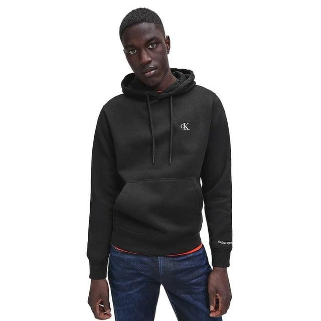 Marca: Calvin Klein Jeans  
Género: Hombre  
Tipo: Sudaderas  
Temporada: Otoño/Invierno  

DETALLES DEL PRODUCTO  
• Color: negro  
• Patrón: liso  
• Cierre: sin cierre  
• Mangas: largas  
• Cuello: capucha  

COMPOSICIÓN Y MATERIAL  
• Composición: -50% algodón -50% poliéster  
• Lavado: lavar a máquina a 30°