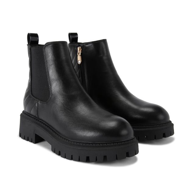 This Carvela Ace Chelsea ankle boot features a black upper with chevron overstitch quilting at the back of the ankle. There is a crystal stud at the back of the ankle with a small patent pull tab.