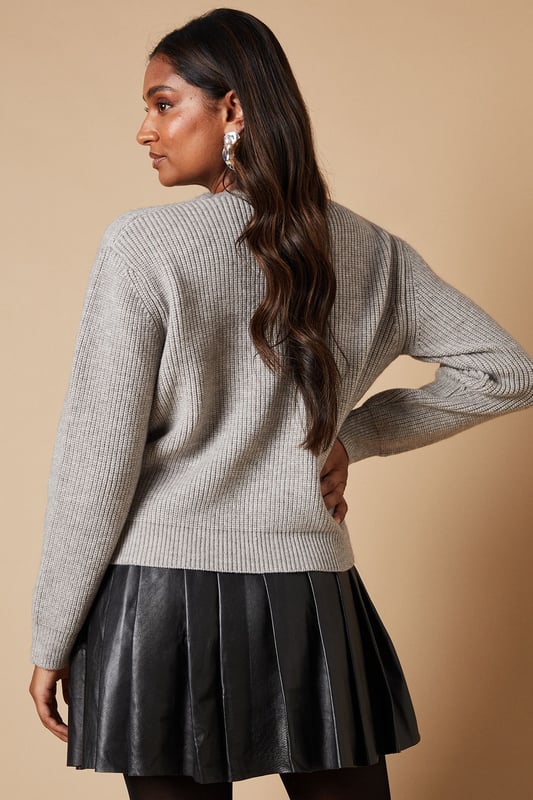 Elegant V-neck design for a flattering neckline
        Charming crystal bow buttons add a touch of sparkle
        Ribbed knit texture for added visual interest
        Versatile cropped length perfect for layering
        Long sleeves for warmth and style
    
    Embrace feminine charm with this Crystal Bow Button Down Jumper from Oasis. The delicate crystal bow buttons lend a touch of whimsy to this otherwise classic piece, making it a versatile addition to your wardrobe. Style it with a pleated skirt and opaque tights for a chic daytime look, or pair it with tailored trousers for a more polished ensemble. The cropped length works wonderfully with high-waisted bottoms, creating a balanced silhouette. For casual outings, throw it over a floral dress and add ankle boots for an effortlessly stylish look. This jumper is perfect for family gatherings, brunch dates, or casual Fridays at the office. Its soft knit fabric ensures comfort, while the ribbed texture adds a subtle sophistication to your outfit.