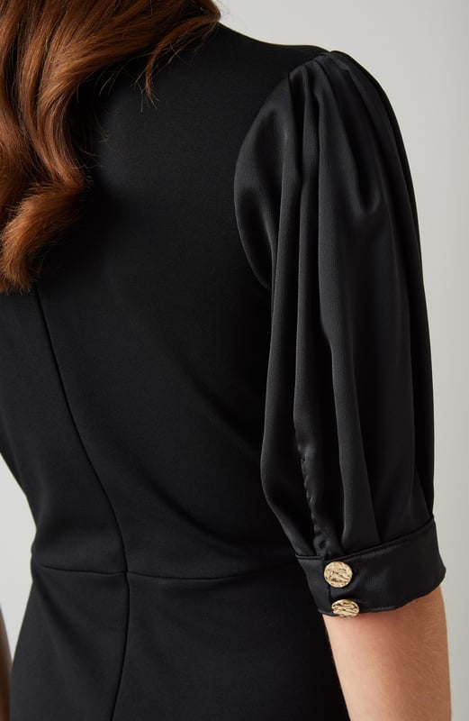 Imagine the perfect blend of sophistication and modern flair. The Daisy crepe dress in timeless black features rib knit trims and dome metal buttons, crafted from luxurious viscose with a stand frill collar and full length sleeves. Pair it effortlessly with ankle boots for a day out or style it with heels for an evening event.