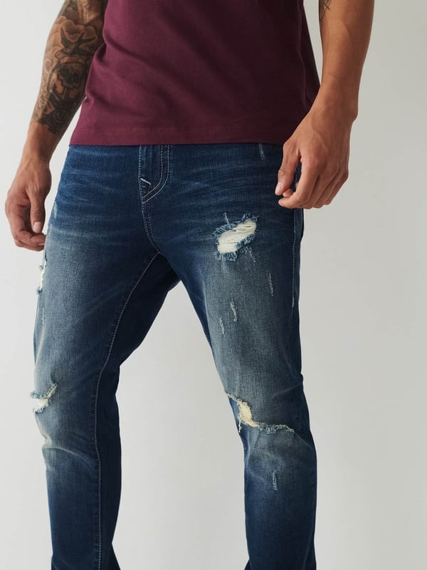 Meet our ultra-slim Jack Jean. This distressed men's super skinny jean features fading, 3D whiskering, and ripped destruction. Finished with two tone stitching, 1/2" horseshoe detailing along the back pockets, and a shorter 30" inseam.