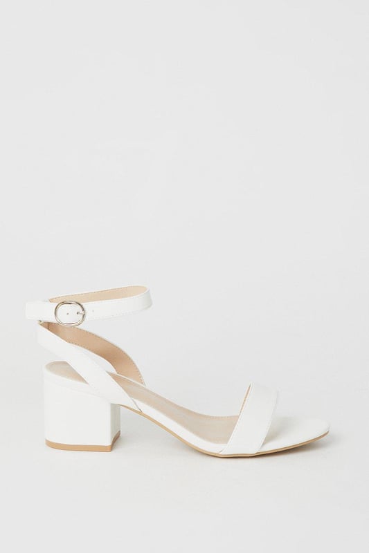 Wide fit design offers a comfortable and accommodating fit
Barely-there strappy silhouette with minimalist appeal
Mid block heel provides a modest lift and walkable height
Faux leather upper exudes a look and feel
Ankle strap with buckle closure ensures a secure fit

These versatile sandals are perfect for casual daytime outings or relaxed evening affairs. Pair them with a flowy midi dress or cropped trousers for a chic, on-trend look that transitions seamlessly from brunch with friends to an evening baby shower. The neutral hue complements a variety of ensembles, allowing you to showcase your personal style effortlessly.