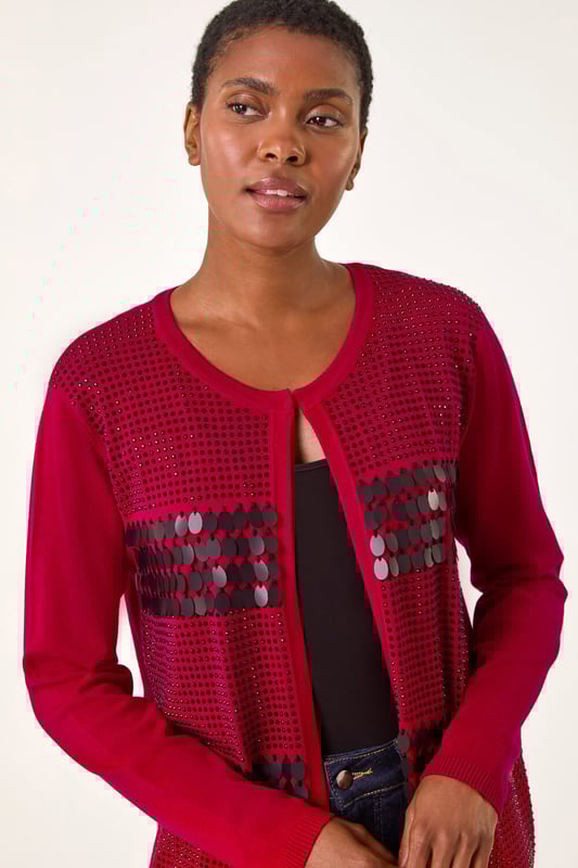 Sequin Embellished Knit Cardigan from Roman. Add a touch of sparkle to your Autumn Winter look with this luxurious sequin embellished knit cardigan. Designed with intricate sparkly details, this soft, knitted long-sleeve cardigan is perfect for any smart or casual event. With a unique front fastening detail and a round neckline featuring hook and bar features, this cardigan is a classic addition to your outfit. Simply style with wide-leg trousers and ankle boots!