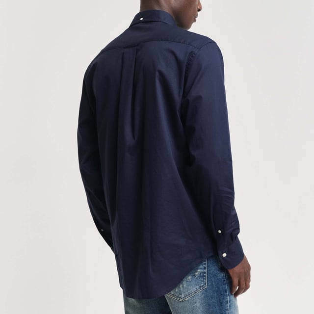 The shirt is made from durable poplin fabric  and is a true classic for your preppy wardrobe. Featuring a rounded hem and an embroidered 1980s-style GANT crest graphic on the chest pocket.