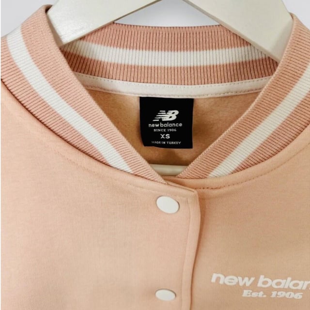 New Balance Womens Varsity Jacket Fleece Contrast Girls Bomber Sweat Jacket     
Regular-fit Jacket is Cut From a Soft and Breathable Cotton Fabric for Lasting Comfort     
This Jacket Features a Button Fastening for Customisable Coverage Whilst Ribbed Trims Optimise the Fit     
Side Pockets     
New Balance Branding to the Chest and Back     
Machine Washable