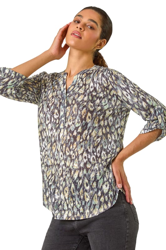 Animal Print Stretch Burnout Top from Roman. Unleash your wild side this Autumn with our fabulous animal print burnout top. Crafted from luxurious jersey fabric, this top features 3/4 tab sleeves and a trendy-notch neckline with a button placket. Falling below the hip, this top is perfect for effortless styling. Pair with your favourite jeans and ankle boots for a fierce and fashionable look that will take you from day to night in style!