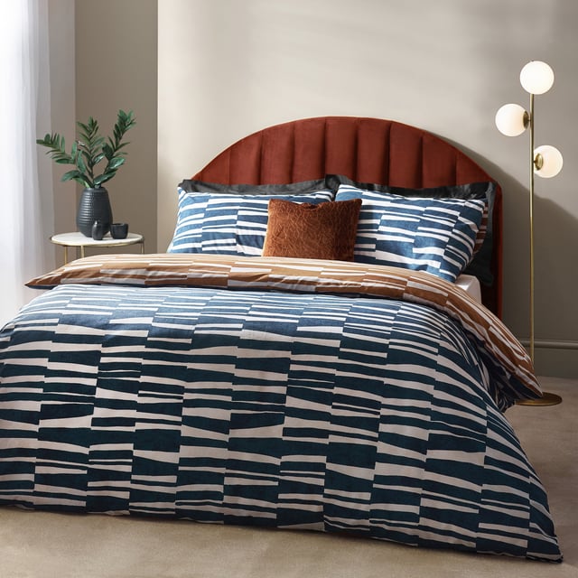 Go to sleep in style with the Piper duvet cover set, inspired by modern, minimalist and abstract art. Create an impact with this modern design, adorned with striking irregular stripes in a tone reminiscence of dusk skies. The reverse features a coordinating print in warming bronze, to offer an alternative design when you need a midweek refresh. A thoroughly modern classic, with a forward-thinking design which will add sophisticated style to your interior. This product is certified by OEKO-TEX® showing it has been sustainably made.