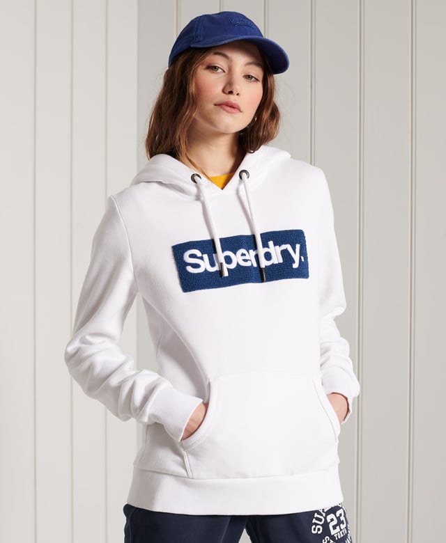 Superdry Core Logo Workwear Hoodie Show your Superdry pride with our Core Logo Workwear Hoodie, featuring a textured logo, soft lining, and a front pouch pocket.Relaxed fit – the classic Superdry fit. Not too slim, not too loose, just right. Go for your normal sizeDrawstring hoodLong sleevesFront pouch pocketRibbed cuffs and hemSoft brushed liningTextured graphic