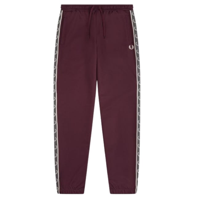 Burgundige Jogginghose mit Fred Perry-Logo, Markenlogo auf dem linken Bein, rote Jogginghose, elastische Taille und Bein. 46 % Baumwolle, 54 % Polyester, hergestellt in Portugal, rote Jogginghose