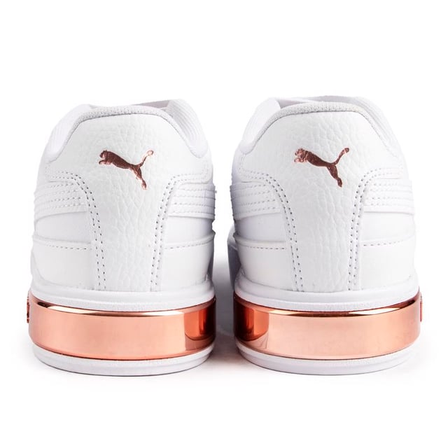 Estas zapatillas blancas Puma Cali Star Glam para mujer tienen una parte superior de cuero suave. un cuello acolchado y un cómodo. plantilla suave. Este estilo presenta una belleza. elegantes detalles metálicos en oro rosa y la icónica raya de Puma para darle un toque glamoroso y estilo añadido.