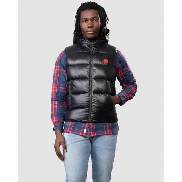 This sporty Water Repellent Puffer Hooded Gilet from HUGO is the perfect piece to elevate your wardrobe this season with sustainable style. Crafted from water-repellent recycled nylon and padded with sustainably sourced recycled fibres providing warmth and comfort. Featuring an insulated hood with full zip closure, elasticated binding and front zip pockets. Finished with a signature HUGO logo patch on the chest.Slim Fit, Water-Repellent Recycled Nylon Shell, Recycled Polyester Padding, Insulated Hood, Full Zip Closure, Twin Zip Front Pockets, Internal Zip Pocket, HUGO Branding. -Style & Fit:Slim Fit, Fits True to Size. Composition & Care:Shell: 100% Recycled Polyamide, Fill: 100% Recycled Polyester, Machine Wash.