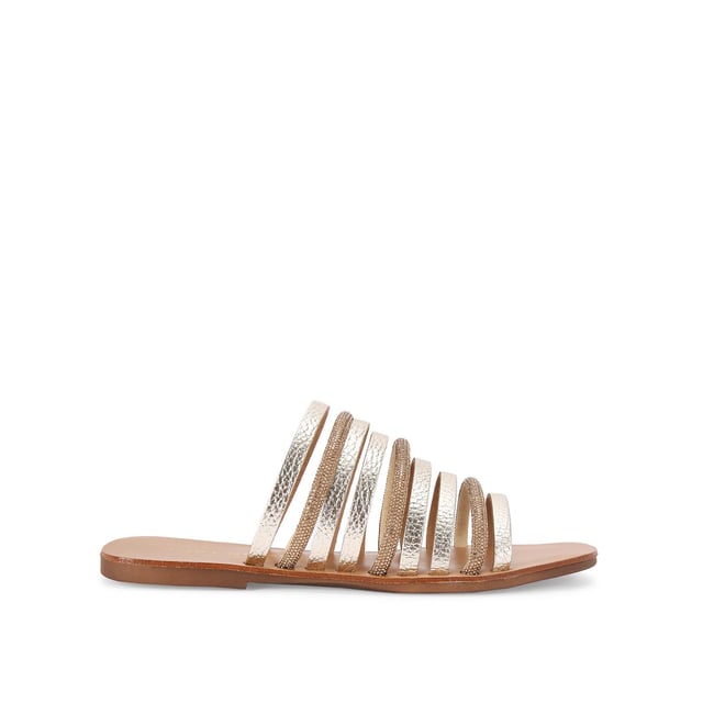 The Kurt Geiger Daisy Flat Sandal is a slip-on sandal. There are multiple gold straps across the upper each with its own metallic finish or crystal embellishment.