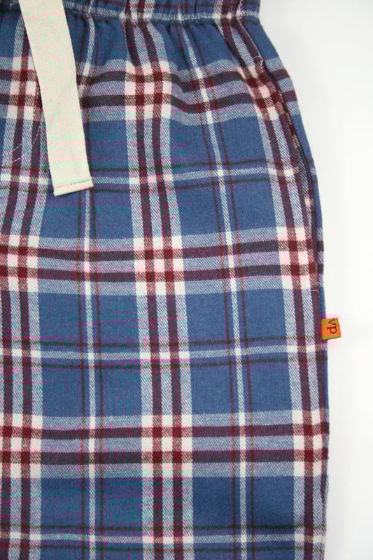 Unisex Lounge pant Pyjama Trouser in Mid blue, Red and White woven check design. 100% Cotton soft brushed woven check fabric. Elastic waist and side pockets. Jersey inner waistband for comfort and an extra drawcord. machine washable. wear them with your favourite T-shirt for that perfect lounge wear outfit.