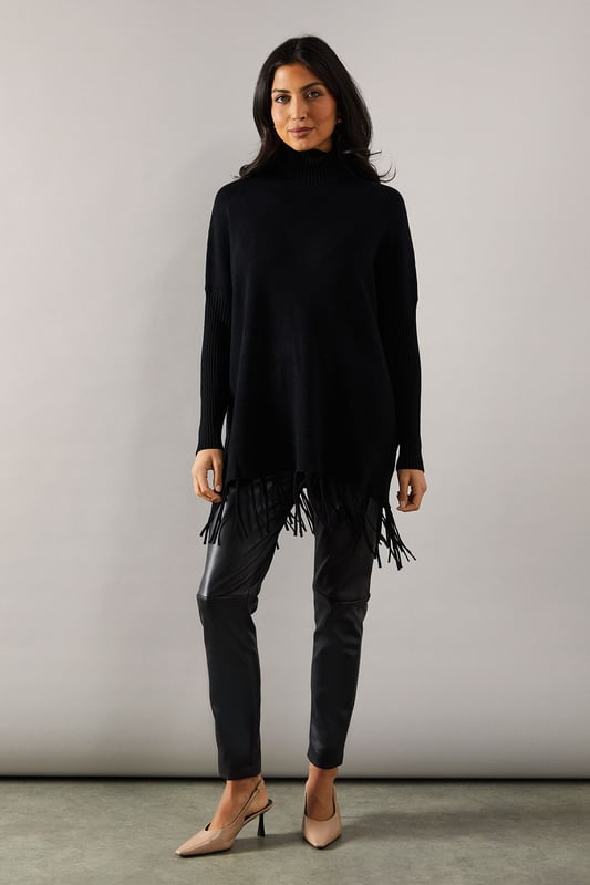 Chic fringed hem poncho design for effortless style
        Cosy roll neck for added warmth and sophistication
        Relaxed fit with dropped shoulders for comfortable wear
        Ribbed cuffs and hem for a polished finish
        Versatile knitted fabric suitable for various occasions
    
    Embrace effortless elegance with this fringed hem roll neck poncho from Wallis. Perfect for the fashion-forward woman who values both style and comfort, this piece offers a sophisticated silhouette that's ideal for casual outings and family gatherings. The relaxed fit and dropped shoulders create a flattering drape, while the roll neck adds a touch of refinement. Style it with slim-fit trousers and ankle boots for a chic daytime look, or layer it over a long-sleeved top with wide-leg trousers for a more dramatic ensemble. The fringed hem adds movement and interest, making it a standout piece in your wardrobe. Whether you're running errands or meeting friends for coffee, this poncho will keep you looking stylish and feeling cosy throughout the day.
