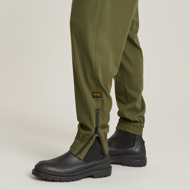 Zip fly, drawcord added. Inset pockets, single back pocket. Stretchable cuffs, relaxed width. Zipper at the lower leg. Pleats inner knee. Zip & button closure. Mid waist. Woven trainer RCT is designed in a loose fit with a relaxed cuff. Inset pockets are combined with a single pocket at the back. The zippers at the ankle add detail. 65% Polyester (Recycled), 35% Elastomultiester. Comfortable stretch. Tapered