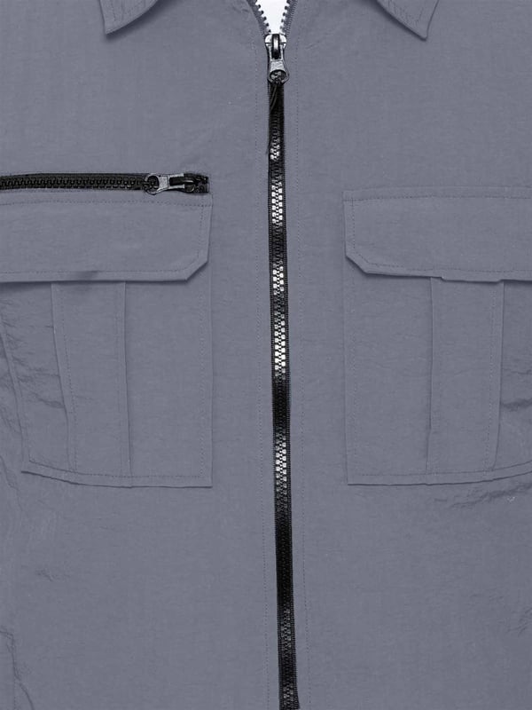 Expertly designed for outdoor activities and the transition to mid-season, this shirt jacket is constructed of crinkle nylon that is both water-repellent and wind-resistant. The fabric has a soft peach-fuzz feel and is complemented by a pointed collar, functional pockets, and a zip fastening to easily adjust the fit. The jacket is made with patch pockets and a flap on the chest, making it both functional and stylish.