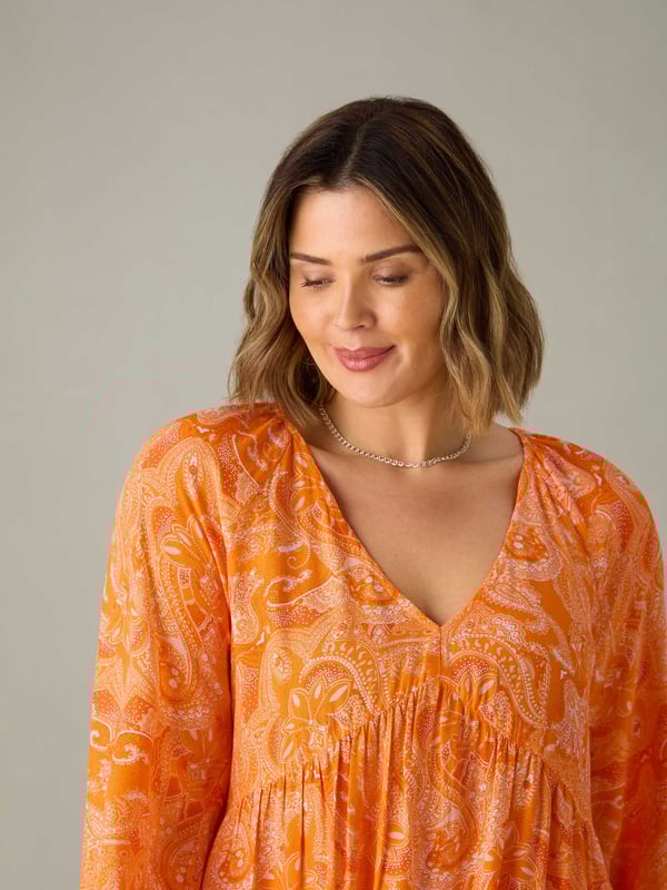 In a pretty orange paisley, this tunic is cut from a soft woven fabric thats so comfortable to wear. With a lengthening V-neckline, it has a bust seam and full-length elasticated sleeves which create a stylish silhouette. Its long, tunic length adds to its flattering feel, making it the perfect everyday piece.
