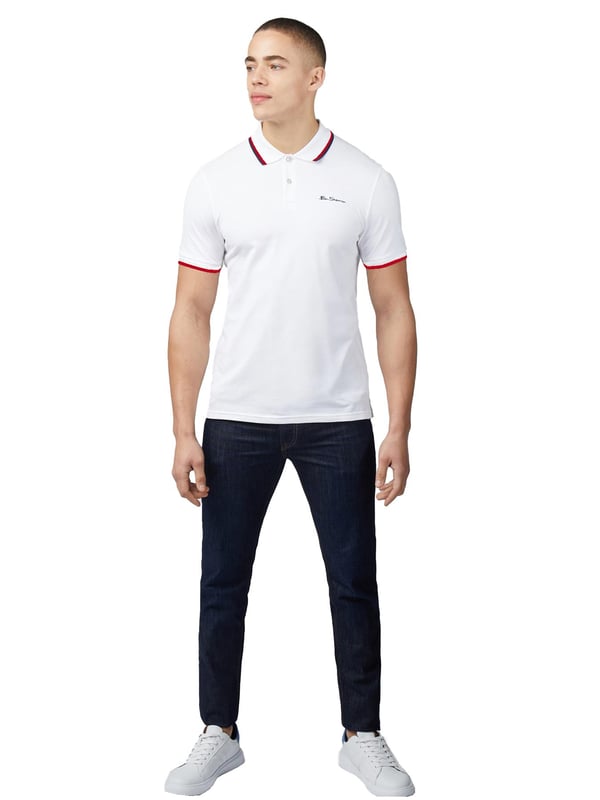 Nuestra icónica camiseta polo está confeccionada con 100% algodón orgánico, ofreciendo un look atemporal para hombres. Este diseño clásico incluye detalles en contraste en el cuello y los puños, añadiendo un toque de estilo. Cuenta con una tapeta de dos botones, un cuello de punto plano y mangas cortas. La camiseta también tiene un bordado en el pecho y está diseñada en un ajuste clásico.