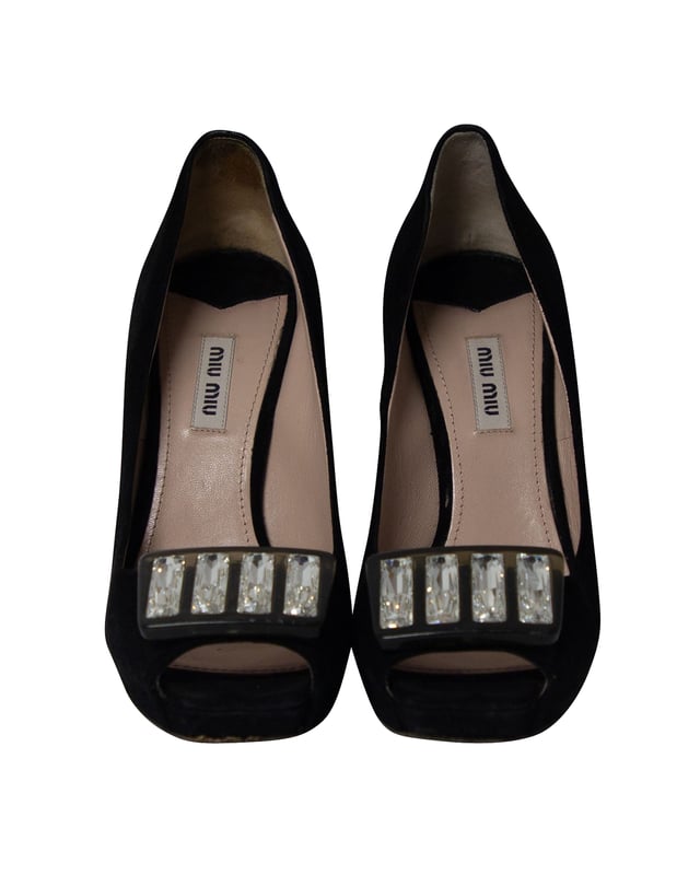 VINTAGE, NEUPREIS WIE NEU  
Verleihen Sie Ihren Füßen Schönheit und Eleganz mit diesen Pumps von Miu Miu. Diese Pumps sind aus schwarzem Wildleder gefertigt und werden durch Kristallverzierungen an der Vorderseite, den offenen Zehen, den Absätzen und den Plateaus akzentuiert. Verbessern Sie den Look Ihres Ensembles, indem Sie diese Pumps stylen.  

Miu Miu Kristallverzierte Peeptoe-Plateaupumps aus schwarzem Wildleder  
Zustand: Gut  
Abnutzungserscheinungen: Mäßige Abnutzung an den Sohlen, Reparaturbedarf an den Fersenlaschen, faire Abnutzungszeichen an den Sohlen, fairer Flusen auf den Schuhen: abnehmbar  
Größe: EU 38/US 8  
Farbe: Schwarz  
Material: Wildleder  
SKU: 196301