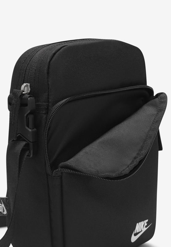 Nike Heritage Cross-Body Men Bag in Black A comfortable and easy-to-adjust strap makes taking the Nike Heritage Waist pack on everyday trips a no-brainer. - -. The main compartment provides secure storage for your phone, snacks or wallet, while the smaller accessories pocket on the back helps keeps things like your keys or travel info safe and close at hand. - -.  The buckle snaps together in the middle of the strap for a comfortable, easy-to-adjust fit. - -. The bag can be worn at your waist, across your body or over your shoulder. - -. Dual zip on the front pocket provides easy access to larger items. - -. Dual zip on the back keeps smaller items stored securely.