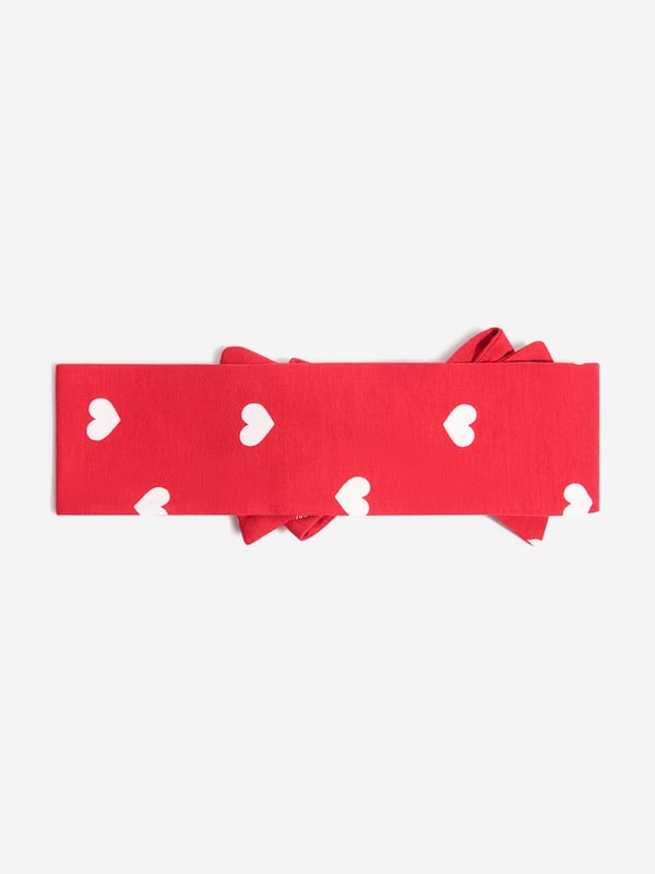 Finish off their look with this pretty red cotton jersey headband by luxury brand, Monnalisa. With a scattering of white hearts this soft and stretchy features a large fixed bow on the front.