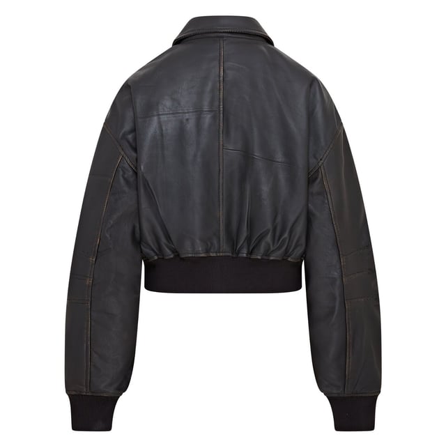 Mejora tu estilo con esta cazadora bomber de piel negra, sencilla y moderna. Diseñada para un look boyfriend relajado y oversize, esta prenda está confeccionada en suave piel de napa de oveja, con costuras y bolsillos envejecidos por expertos para un aspecto vintage. Una robusta cremallera YKK da lugar a un cuello clásico estilo camisa, mientras que el dobladillo y los puños de punto elástico garantizan un ajuste ceñido y calidez. Con dos bolsillos en la cintura y un bolsillo en la manga con cremallera, además de un lujoso forro de satén con un bolsillo interior con ribete de piel, esta cazadora combina funcionalidad con una sofisticación vanguardista. Piel de napa de oveja envejecida suave, corte oversize, cremallera YKK gruesa, dobladillo y puños de punto elástico, forro de satén con bolsillo interior con ribete de piel
