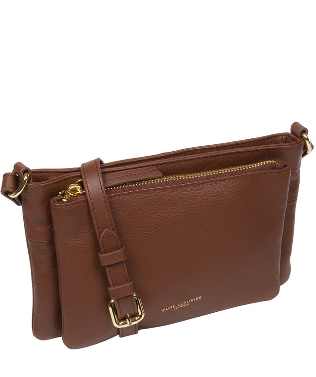 Handcrafted from super soft natural Nappa leather, the 'Jess' cross body bag from Pure Luxuries London's Marylebone Collection is a must-have thanks to the spacious design. The dual main compartments are secured with a zip-over top which opens to reveal the luxurious 10% cotton lining. Additional storage space is provided by two slip pockets in the larger compartment - ideal for maintaining an organised bag. The accessory is adorned with gold-coloured metal fittings and zips which complement the slim and adjustable leather strap with a maximum drop length of 65cm. The Pure Luxuries logo is embossed in gold foil for a beautifully simple finishing touch.