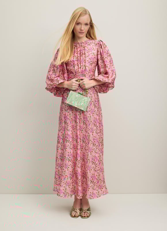 A beautiful new dress in our Royal Ascot collection, the Lois is pretty in pink with a reimagition of a French mid 19th century print. Crafted from a slinky viscose-silk blend in pink with a squiggle jacquard and a neon garden print, it has a round neck with pleating detail, puff shoulders, voluminous balloon sleeves and a long, floaty cut falling to a midi length. Wear it with heels and a hat to cheer on the winners.