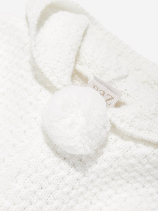 Wrap your little one in the epitome of elegance with the Paz Rodriguez Baby Wool Knitted Coat in Ivory. Crafted in Spain, this luxurious coat offers both warmth and style for AW2024: Exquisite Craftsmanship: Handmade in Spain, ensuring unmatched quality and attention to detail.   Pure Wool: Made from soft, premium wool for ultimate comfort and warmth.   Timeless colour: The ivory hue ensures versatility and classic style.   Unisex Design: Perfect for boys and girls, making it an ideal wardrobe staple.  Elevate your child's fashion this season with this exclusive, cosy coat!