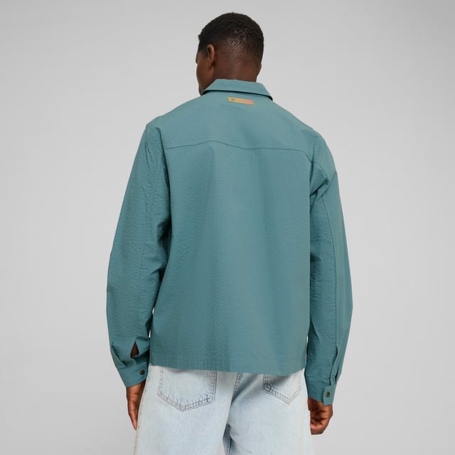 PRODUCT STORY: Marking 30 years of Definitely Maybe, its Definitely City. Co-designed by Noel Gallagher, a lifelong Man City fan, this relaxed fit overshirt pays homage to an album that defined an era. FEATURES & BENEFITS: Made with at least 20% recycled cotton. DETAILS: Relaxed fit; 165gsm, seersucker; Collar; Button placket; Long sleeves; Official team branding details. Our model is 186 cm tall and is wearing size M UK.