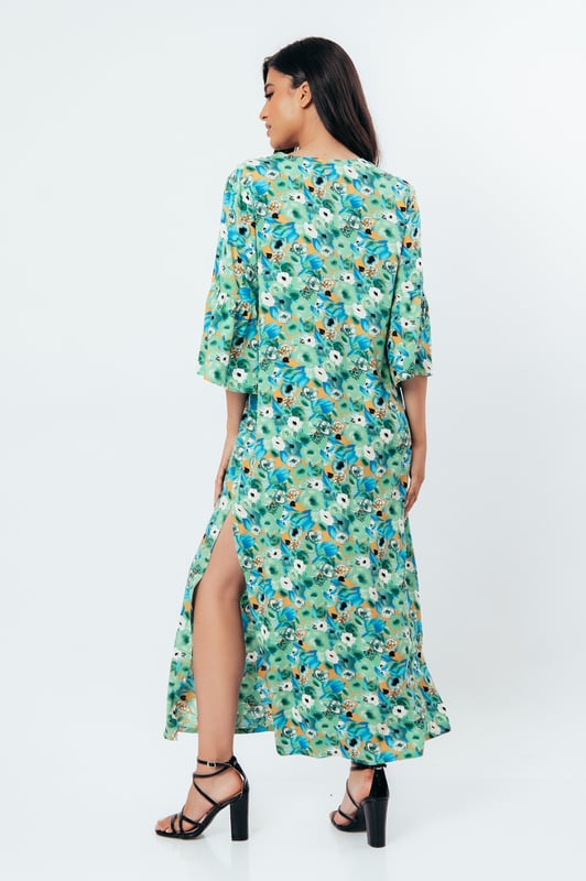 Deze zomerjurk in kaftanstijl met bloemenprint is gemaakt van geweven viscose. Het heeft een mandarijnkraag en een V-halslijn. De mouwen zijn lang met ruches aan de manchetten. De zoom heeft grote zijsplitten. Deze jurk heeft een lang, los, recht silhouet.