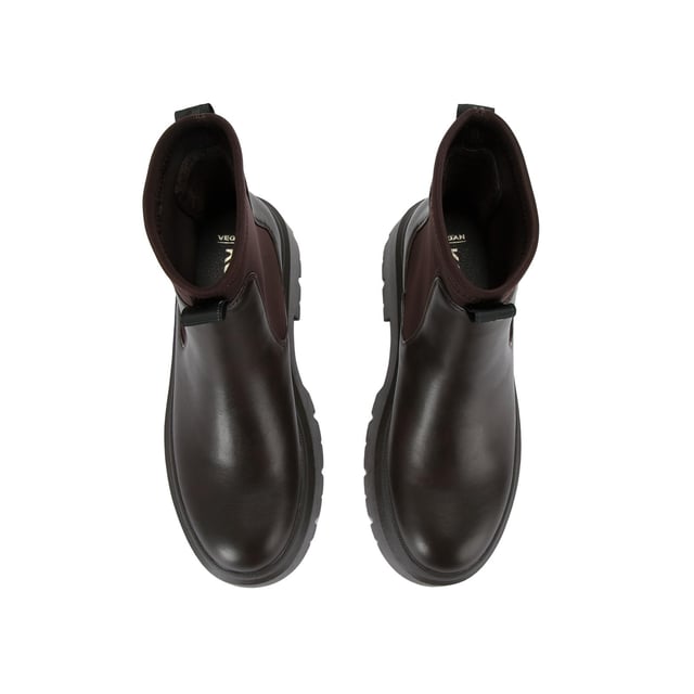 The KG Kurt Geiger Thea is a brown boot with chunky style, there is a stretch ankle for slip-on ease. The sole is extra chunky with large tread. the back of the ankle features a brown monocle and KG Kurt Geiger branded tape.