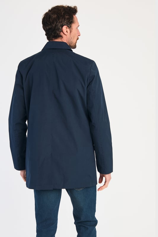 This men's mac-style coat from Kensington Eastside features a classic collar, button-up fastening, and a mid-length cut for a sleek, modern look. Lightweight and stylish, it’s perfect for layering over both casual and formal outfits, making it a versatile wardrobe essential for effortless style.