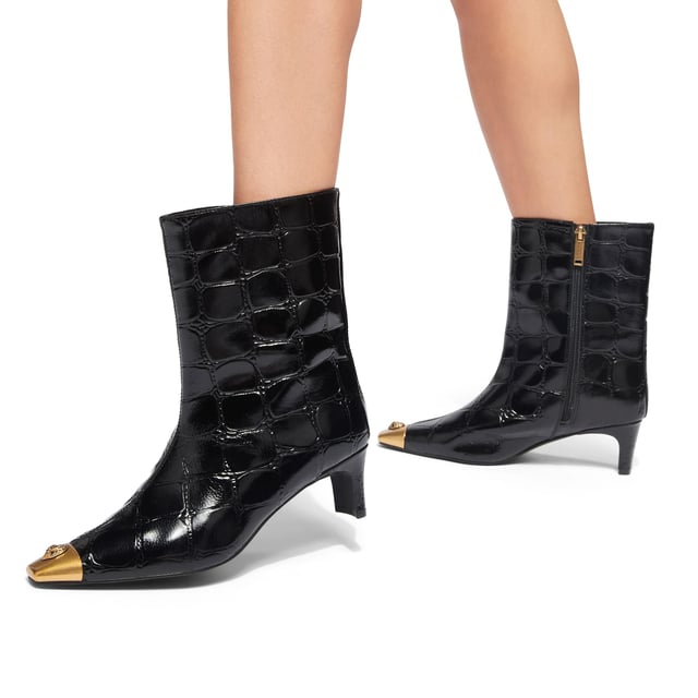 This Kurt Geiger Regent Ankle Boot features a black croc embossed upper with antiqued brass toe cap. There is an antiqued brass eagle head sat on top of the toe all sat on a fashionable kitten block heel. Heel height: 5.5cm.