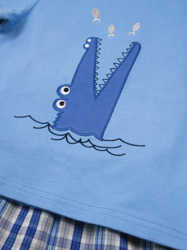 Our crocodile is guaranteed not to bite  - it only snaps!! Our shortie cotton pyjamas set brings some fun to bedtimes!

Made from 100% super soft cotton. The soft jersey mid blue top, with the a Snappy Crocodile embroidery applique has a matching rib neck, so easy to put on and off. The shorts have a fully soft elasticated waist and are made in a crisp summer cotton woven blue check.  We are sure these will be a firm favourite this summer!

Sold as a Pyjama set
Smiley Crocodile Applique
Fabric: 100% cotton
Fire Warning : KEEP AWAY FROM FIRE AND FLAMES.
Wash Care Instructions : Machine wash inside out, do not soak, wash dark colours separately. Do not iron trims or motifs. Save energy and wash at 30 degrees.
Do not tumble dry