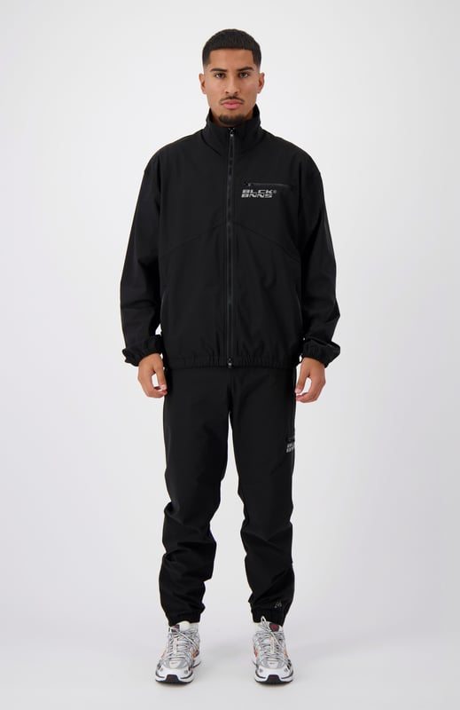 90 % Nylon | 10 % Elastan Elastischer Bund Schwarzes BNNS-Logo auf dem linken Bein Zwei Reißverschluss-Fronttaschen Kombinierbar mit INITIAL TECH JACKET 