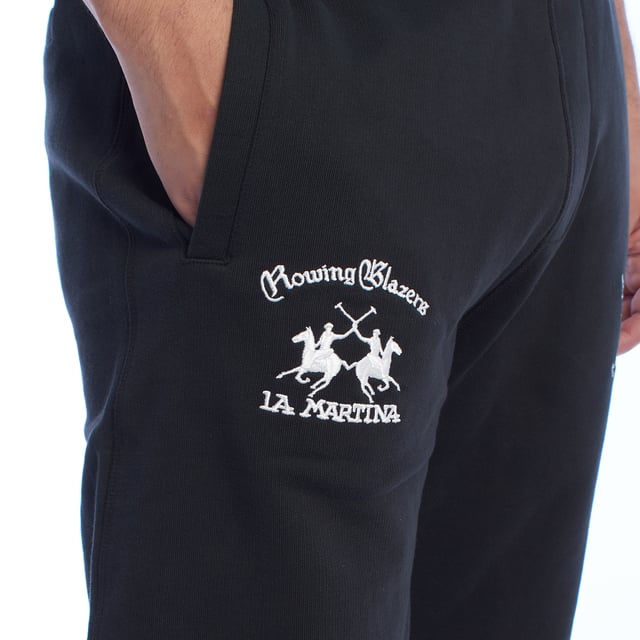 Pantalón de chándal para hombre de La Martina.

Estilo y elegancia se combinan en este pantalón deportivo de La Martina, diseñado para los hombres que buscan comodidad sin renunciar a un diseño exclusivo. 

Detalles:

- Fabricado en algodón de alta calidad, suave y transpirable, para garantizar comodidad durante todo el día.
- Cintura elástica que asegura un ajuste cómodo y seguro en cualquier actividad.
- Bordados exclusivos de La Martina en ambos lados del pantalón, destacando el logotipo y un león rojo icónico que aportan un detalle único y sofisticado.
- Bolsillos laterales amplios y funcionales, ideales para guardar pequeños objetos de manera práctica.
- Bolsillo trasero de ribete con bordado decorativo, combinando funcionalidad y estilo elegante.
- Corte relajado con puños en los tobillos.

Este pantalón deportivo hombre de La Martina es la elección ideal para quienes buscan una prenda que combine confort, diseño exclusivo y detalles únicos como sus bordados distintivos. Perfecto para lucir con estilo en el día a día.
 Composición: 100% Algodón
 Cuidados:
- Lavar máximo a 30°C en ciclo suave.
- No usar lejía ni blanqueadores.
- No secar en secadora.
- Planchar a baja temperatura si es necesario, evitando los bordados.