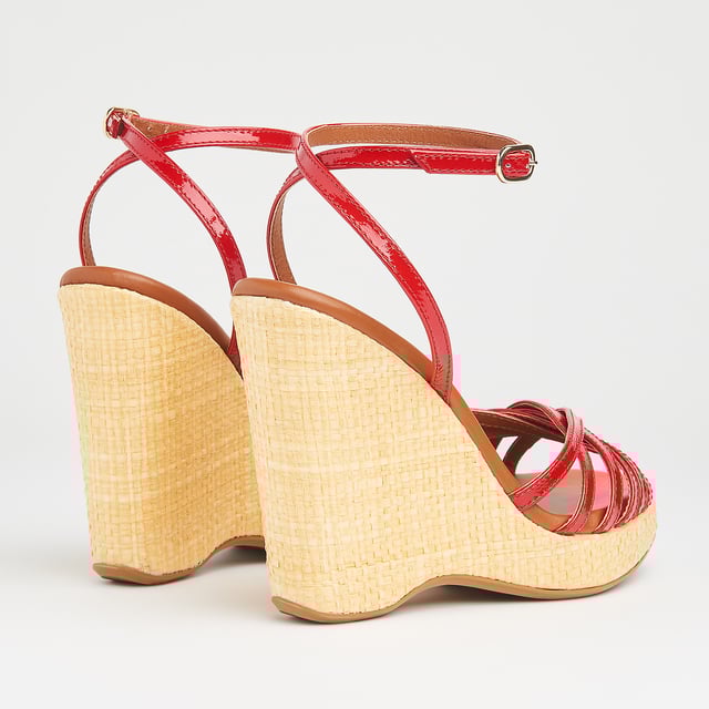 With a hint of Seventies' playfulness, our Solange wedges balance height and comfort. Crafted in Italy from red patent leather, they have a crossover multi-strap design, a delicate ankle strap and a beige raffia 110mm wedge sole. Perfect with summer's cool cotton and linen skirts and dresses, they're also great with wide leg trousers.